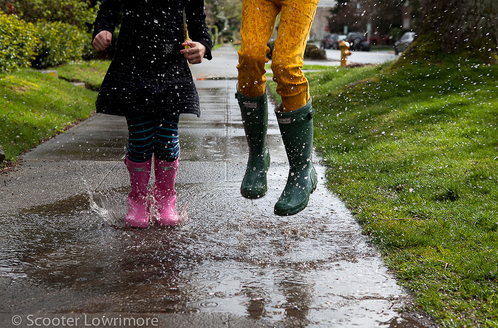 jumping in puddles on sidewalk